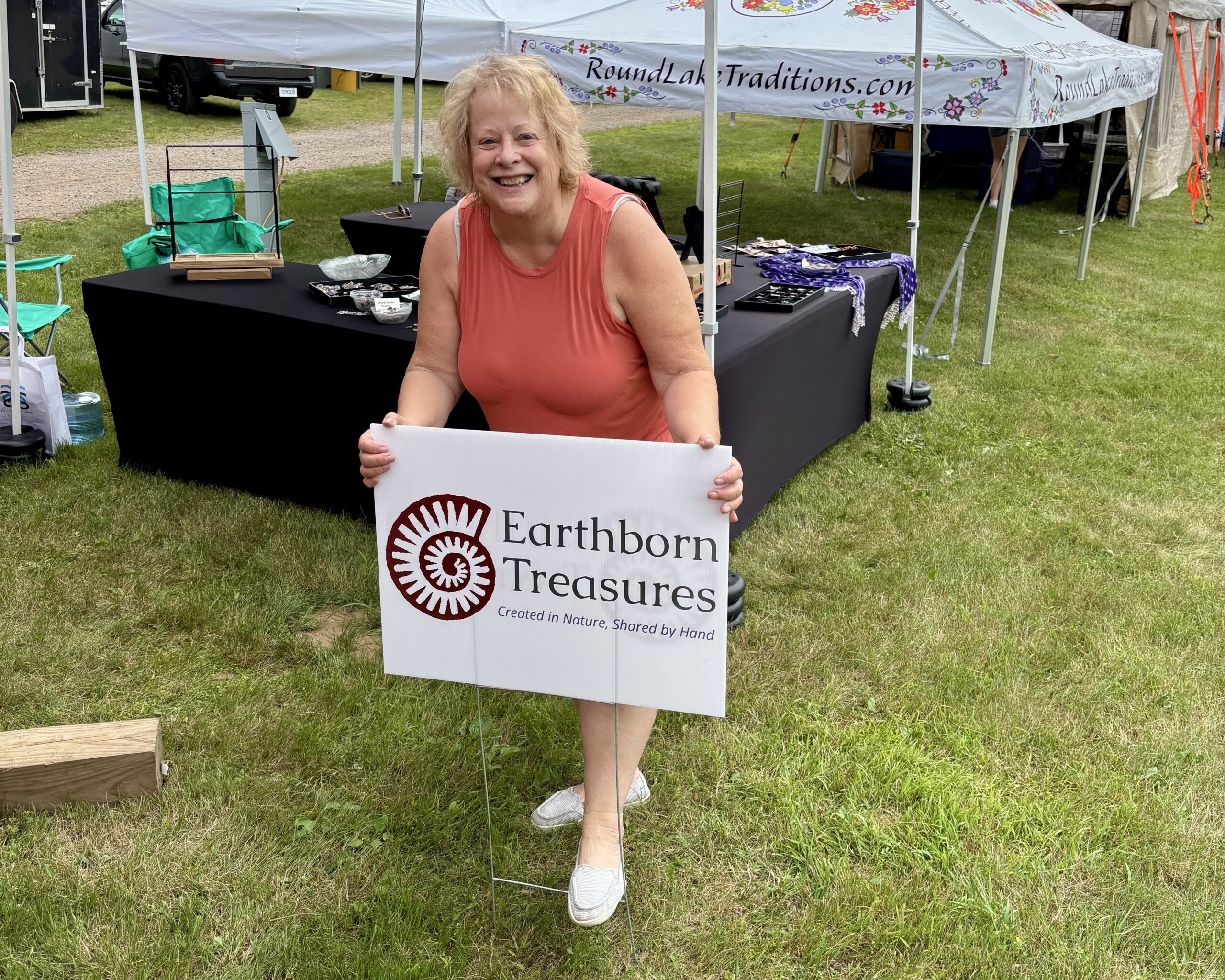 image of a woman putting an Earthborn Treasures sign in the ground